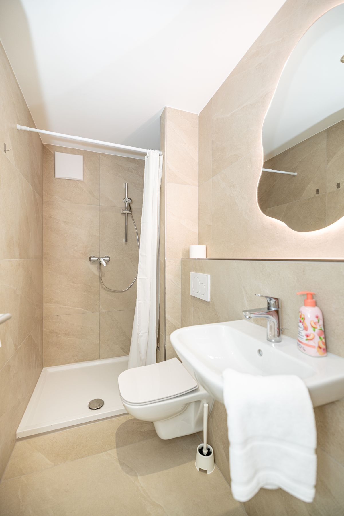 Bad mit Dusche und beleuchtetem Spiegel