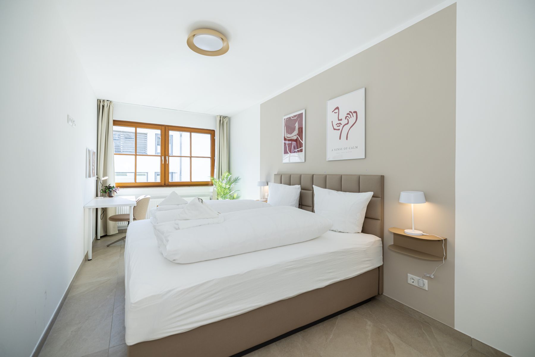 Helles Schlafzimmer mit Doppelbett und Holzfenster