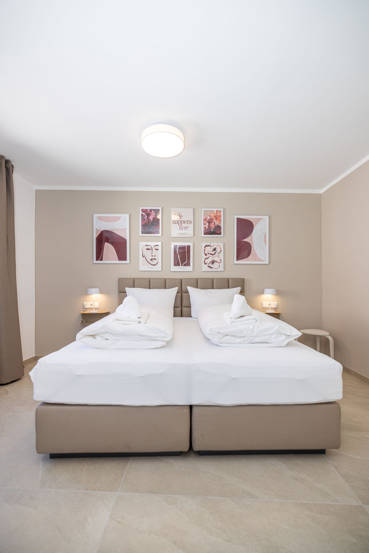 Schlafzimmer mit Doppelbett und Wandbildern