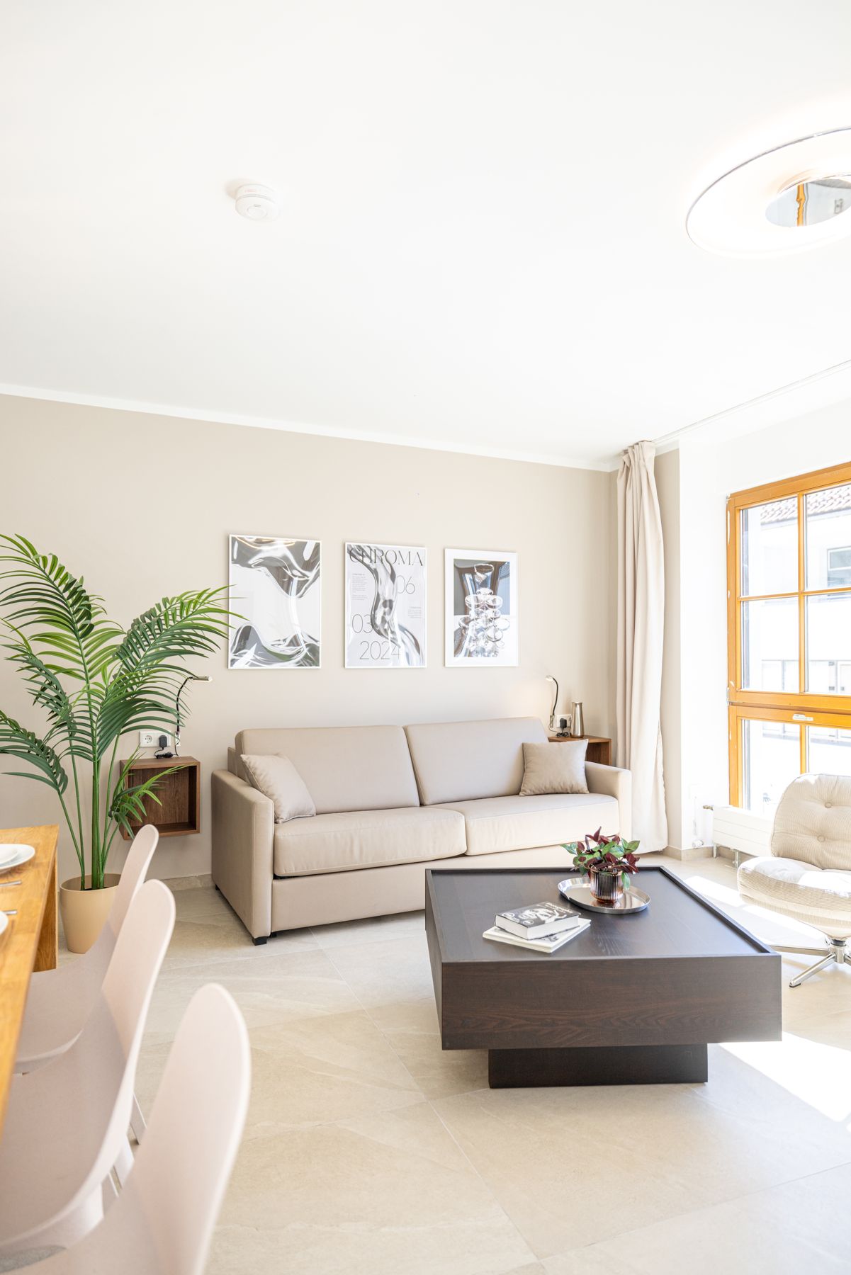 Wohnbereich mit Sofa, Couchtisch und Holzfenstern